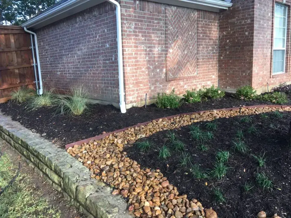 Residential bed, low retaining wall, and stone drainage channel